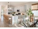 Bright kitchen with stainless steel appliances, a center island with seating, and adjacent dining area at 9097 Wildlight Trl, Wildwood, FL 34785