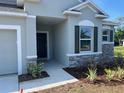 Close up view of a home's entrance and garage, showcasing stone accents and well-maintained landscaping at 121 S Cory Dr, Edgewater, FL 32141