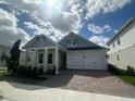 Attractive single-story house boasting a brick driveway, two-car garage, and welcoming covered entrance at 15086 Summer Harvest St, Winter Garden, FL 34787