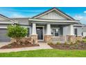 Close up of the charming single-story home with a covered front porch, and manicured front lawn at 2982 Arranmore Dr, Ormond Beach, FL 32174