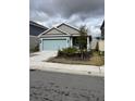 Two-toned home with light teal garage door and small front porch at 207 Aqua Ave, Davenport, FL 33837