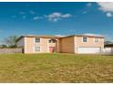 Inviting two-story home featuring a large front yard and an attached two car garage at 2824 Corrigan Dr, Deltona, FL 32738