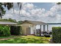 A covered boathouse on a grassy lawn near the lake, featuring a fenced gate and wooden deck at 786 Antonette Ave, Winter Park, FL 32789