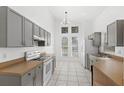 Gray cabinets, white appliances, and light tile floors at 230 Bay Meadow Dr, Kissimmee, FL 34746