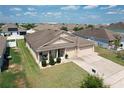 Aerial view of a well-kept single-story home with a three-car garage, and a lush green lawn at 236 Barrington Dr, Haines City, FL 33844