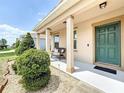 Inviting covered front porch with decorative columns, a comfortable bench, and manicured landscaping at 236 Barrington Dr, Haines City, FL 33844