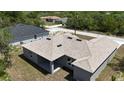 Overhead view of the tan-roofed home, highlighting the backyard and surrounding neighborhood at 1202 Alafia Way, Poinciana, FL 34759