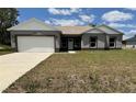 Charming single-story home with a two-car garage and well-maintained front lawn at 1202 Alafia Way, Poinciana, FL 34759
