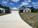 Charming single-story home with a well-manicured lawn, a spacious driveway, and a two-car garage at 1314 Hillsborough Ct, Poinciana, FL 34759