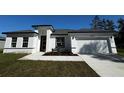 Single-story home features a well-manicured lawn, bright white exterior, and a driveway at 3041 Sw 168Th Loop, Ocala, FL 34473