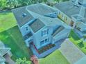 Aerial view of a two-story home with a brick driveway, lush landscaping, and a well-maintained roof at 3207 Stratton Cir, Kissimmee, FL 34744