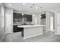 Spacious kitchen featuring a large island, dark cabinets, and modern stainless steel appliances at 3207 Stratton Cir, Kissimmee, FL 34744