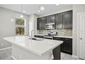 Modern kitchen with stainless steel appliances, dark cabinetry, backsplash, and a bright island at 3207 Stratton Cir, Kissimmee, FL 34744