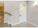 Modern entryway with light gray walls, wooden staircase, and white door at 7770 Sandy Ridge Dr # 110, Reunion, FL 34747