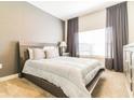 Stylishly decorated bedroom featuring a neutral palette, plush bedding, and large window with natural light at 8943 Cabot Cliffs Dr, Davenport, FL 33896