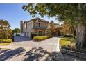 Elegant home exterior with a brick driveway and lush landscaping at 2115 Lake Crescent Ct, Windermere, FL 34786