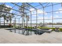 Screened pool and patio with lake view, fire bowls, and modern tile at 6009 Lady Bet Dr, Orlando, FL 32819