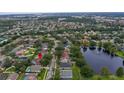 Aerial view of a suburban neighborhood with a pond and houses with private pools at 807 Grovesmere Loop, Ocoee, FL 34761