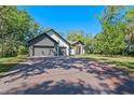 Beautiful exterior view features a long brick driveway, well-maintained lawn, and three car garage at 347 Mission Rd, Oviedo, FL 32765