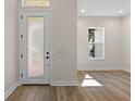 Bright foyer with hardwood floors, a frosted glass door, and a view into the living area at 347 Mission Rd, Oviedo, FL 32765