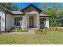 Inviting home entrance featuring stone accents, manicured landscaping, and a brick pathway at 347 Mission Rd, Oviedo, FL 32765