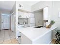 Small galley kitchen features white cabinets, stainless steel appliances, and a breakfast bar at 4408 Sun Village Blvd, Kissimmee, FL 34746
