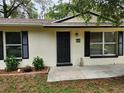 Inviting home entrance, featuring dark-colored shutters and a well-manicured yard at 849 Orange Oak Dr, Orange City, FL 32763