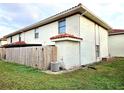 Rear view of home showcasing a wooden privacy fence and AC unit at 1609 Little Falls Cir # 79, Orlando, FL 32807