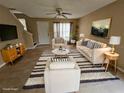 Virtually staged living room with beige sofas, striped rug, and tiled floors at 1609 Little Falls Cir # 79, Orlando, FL 32807