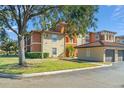 View of a multi-unit building with tile roof, manicured lawn, and detached garages at 5578 Metrowest Blvd # 101, Orlando, FL 32811