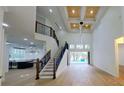 Bright open-concept living room with high ceilings, hardwood floors, and a staircase leading to the second floor at 1003 Oakdale St, Windermere, FL 34786