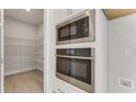 Stainless steel microwave and oven combo beside a white pantry with metal racks at 1209 Cresswind Blvd, Deland, FL 32724