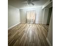 Bright bedroom features wood-look tile floors and neutral-toned curtains for a calm aesthetic at 1234 Sago Palm Blvd # 1234, Kissimmee, FL 34741