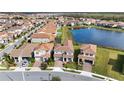 Aerial neighborhood view of a two-story home with tiled roof, situated near a tranquil lake at 13333 Oakenshaw Ln, Orlando, FL 32832