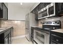 Kitchen featuring stainless steel appliances and dark cabinetry at 5929 Windhover Dr # A02, Orlando, FL 32819