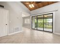 Bright living room featuring tile floors, wood vaulted ceiling, and sliding glass doors to the outside at 5929 Windhover Dr # A02, Orlando, FL 32819
