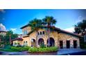 Community clubhouse with palm trees and landscaping at 904 Charo Pkwy # 536, Davenport, FL 33897