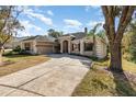 Two-story house with a driveway, landscaping, and mature trees at 6689 Bell Glade Pl, Sanford, FL 32771