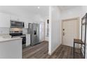 Bright kitchen featuring white cabinetry, stainless steel appliances, and wood-look flooring at 100 Palermo St, Davenport, FL 33897