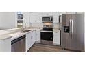 Modern kitchen with stainless steel appliances, white cabinets and light countertops at 100 Palermo St, Davenport, FL 33897