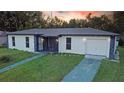 Well-maintained single-story home with neutral paint, dark trim, attached garage, and a green lawn at 1048 Wakefield Cir, Deltona, FL 32725