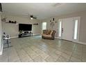 Spacious living room with tile floors, a ceiling fan, and a front door with sidelights at 1048 Wakefield Cir, Deltona, FL 32725