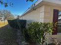 Side view showcasing the home's exterior and neatly trimmed hedges at 9875 Sw 55Th Ct, Ocala, FL 34476