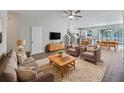 Inviting living room featuring neutral tones, modern furniture, ceiling fan and an open-concept layout at 1106 Presidential Ln, Apopka, FL 32703