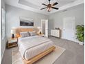 Serene main bedroom featuring a tray ceiling, ceiling fan, a walk-in closet, and an ensuite bathroom at 1106 Presidential Ln, Apopka, FL 32703