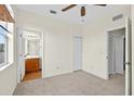 Spacious bedroom with neutral carpet, ceiling fan, and adjacent bathroom and closet entrances at 13228 Daniels Landing Cir, Winter Garden, FL 34787