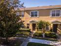 Townhome featuring a well-maintained facade with landscaped gardens and a paved walkway leading to the entrance at 13228 Daniels Landing Cir, Winter Garden, FL 34787