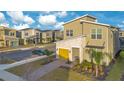 Two-story house with yellow garage door and landscaped yard at 571 Drop Shot Dr, Davenport, FL 33896