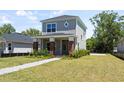 Well-maintained home featuring gray siding, complemented by a well manicured lawn and brick accents at 813 S Locust Ave, Sanford, FL 32771