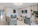 Spacious living room with gray sofas, a large TV, and stylish decor at 1179 Kingsbarn St, Davenport, FL 33896
